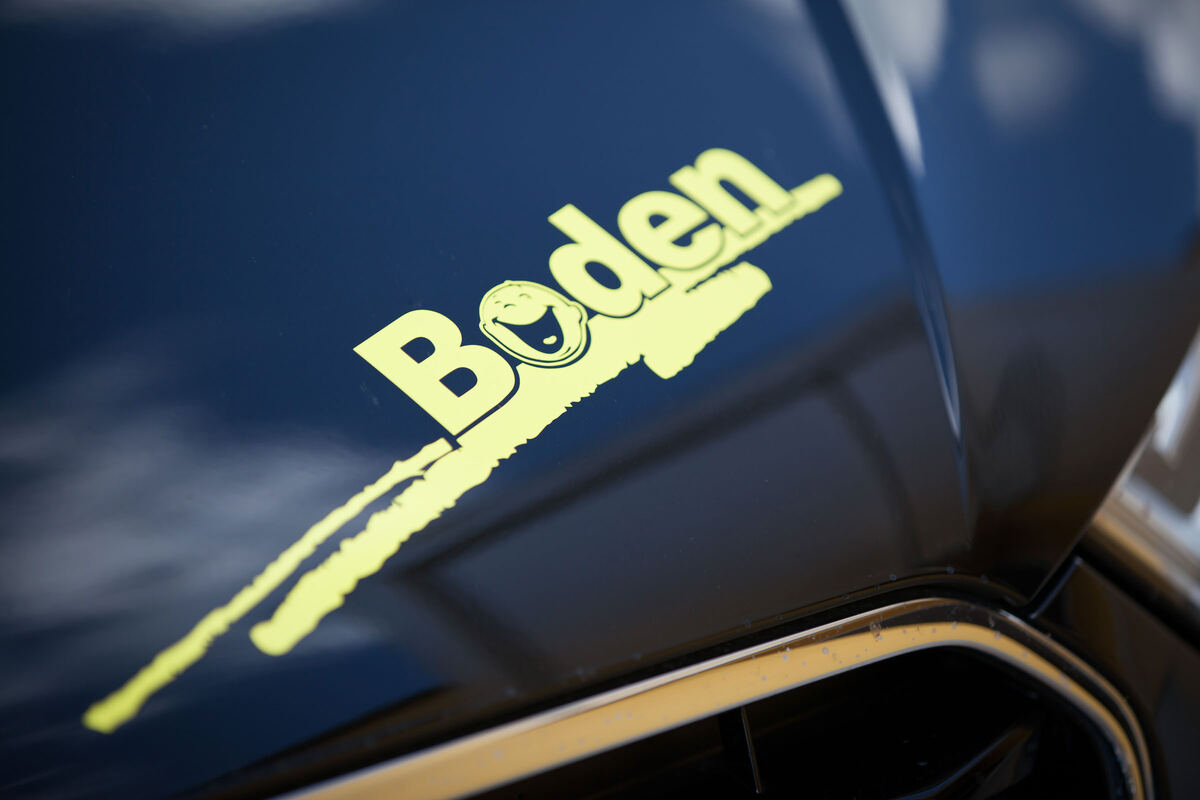 Gelber Boden-Schriftzug auf einem dunkelblauen Fahrschulfahrzeug